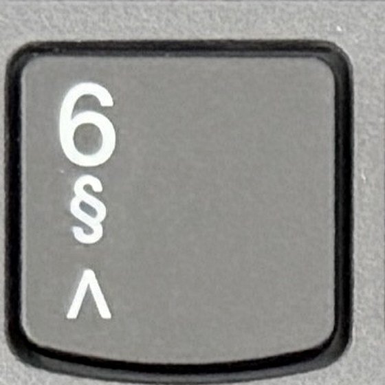 Close-up van de 6-toets op een Belgisch AZERTY-toetsenbord met het paragraafteken eronder