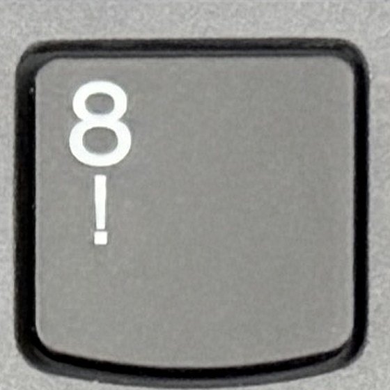 Close-up van de 8-toets op een Belgisch AZERTY-toetsenbord met het uitroepteken eronder