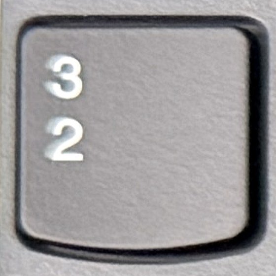 Close-up van de toets links van de 1 met de tekens superscript drie en superscript twee