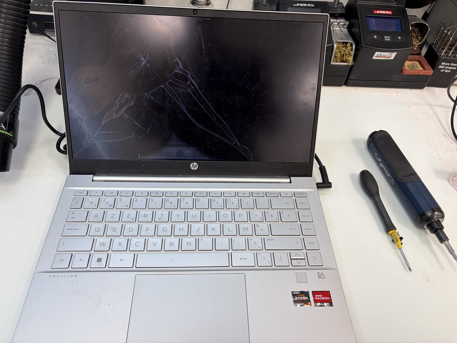 Gebarsten laptopscherm van een HP Pavilion 14-ec1009nb met een spinnenwebbreuk vanuit het inslagpunt links in het beeld