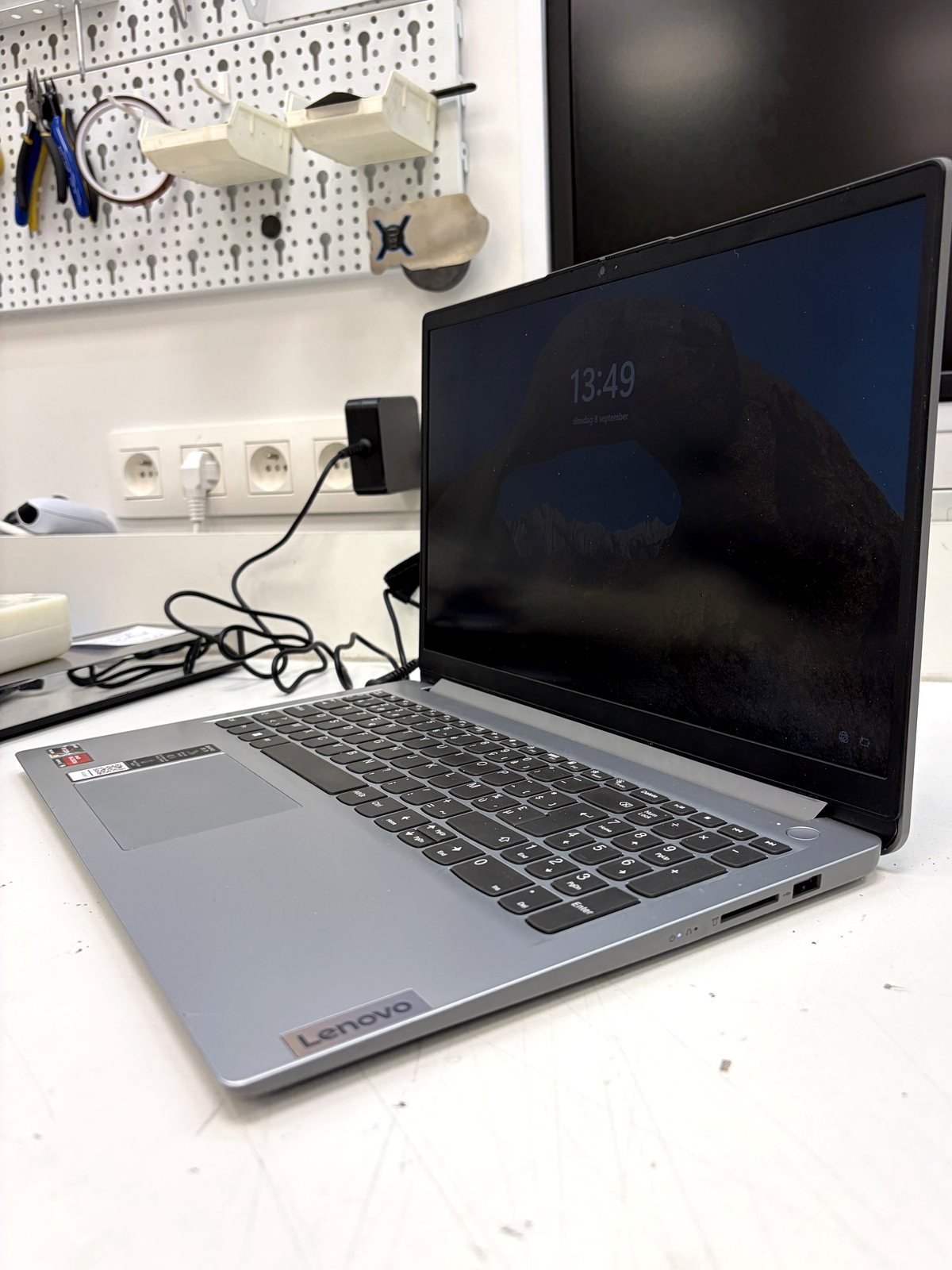 Lenovo laptop na scharnierherstelling, open en aangezet op de werkbank van ZeliT