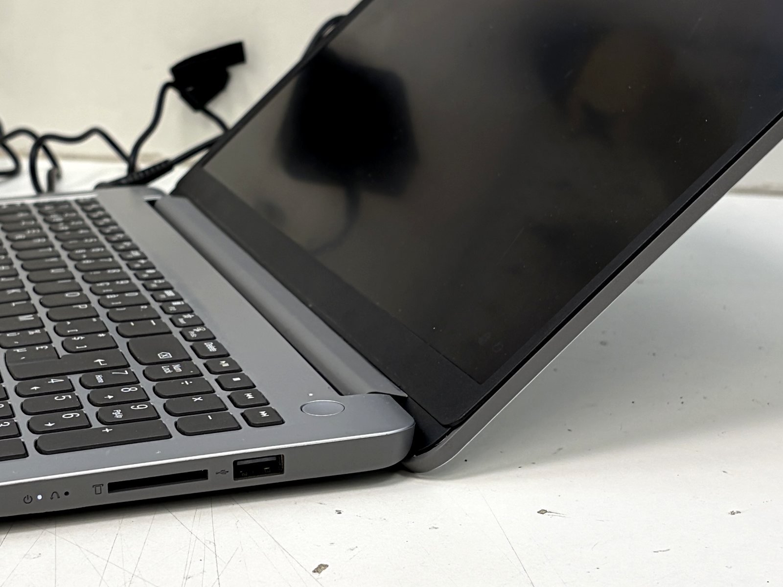 Zijaanzicht van een laptopscharnier na herstelling; het scherm blijft in de ingestelde hoek staan