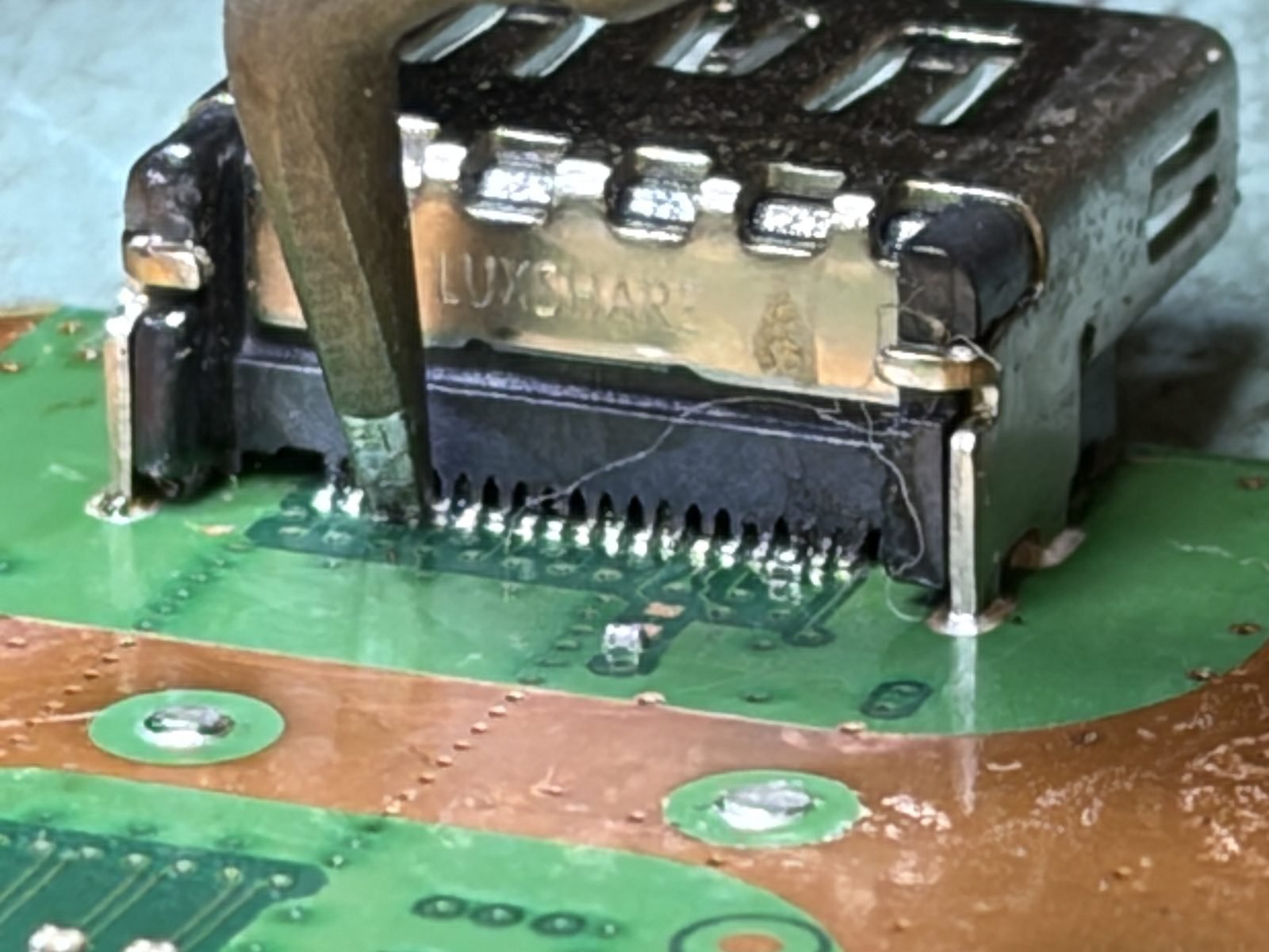 HDMI-poort vastsolderen op PS5 moederbord onder microscoop