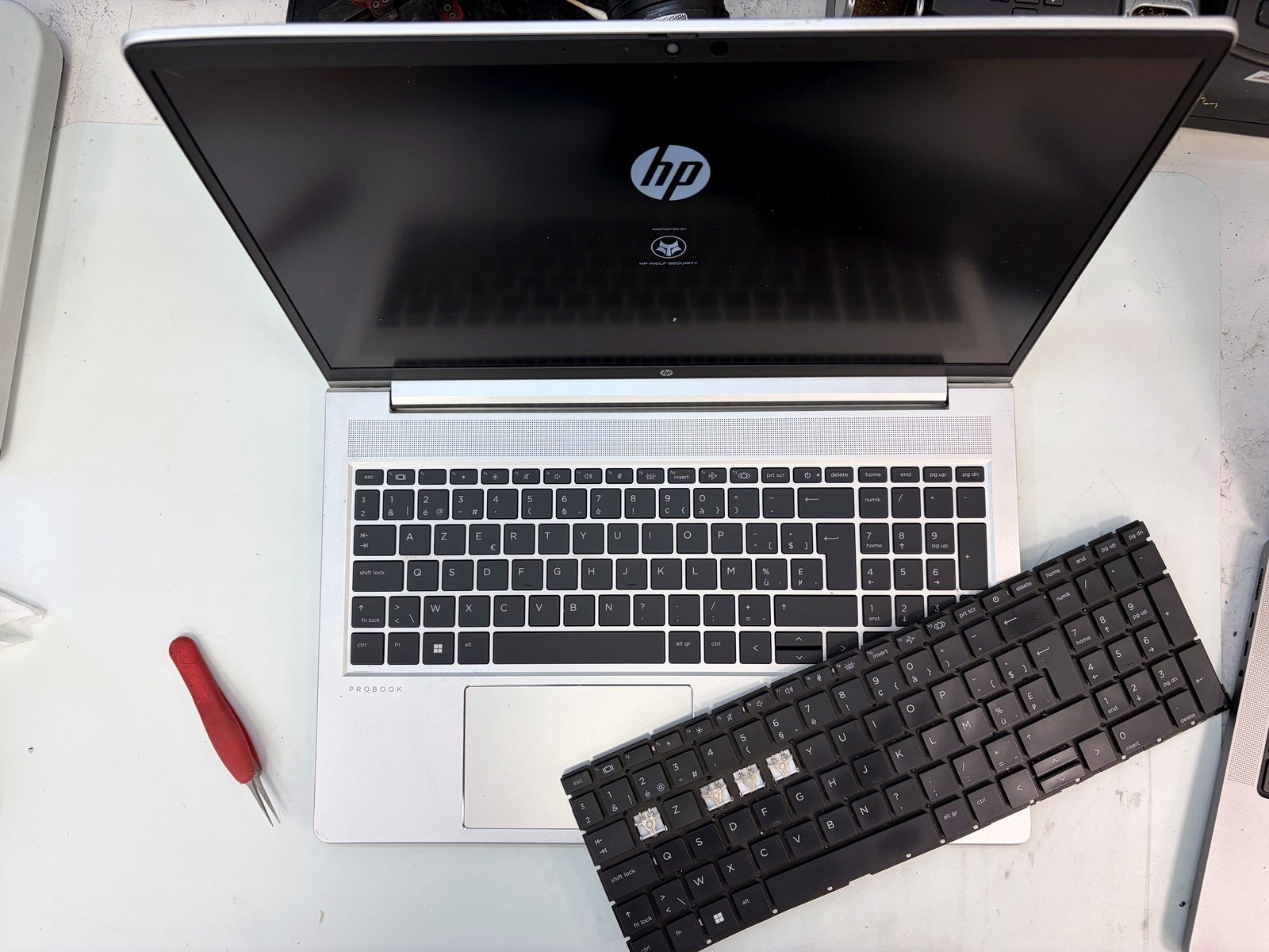 HP ProBook met nieuw Belgisch AZERTY-toetsenbord, het oude bord ligt ernaast