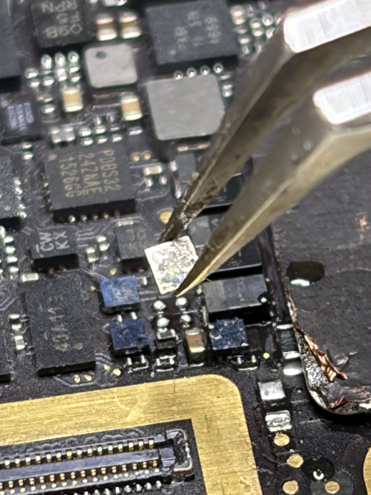 Een aangetast component wordt onder de microscoop vervangen op het moederbord