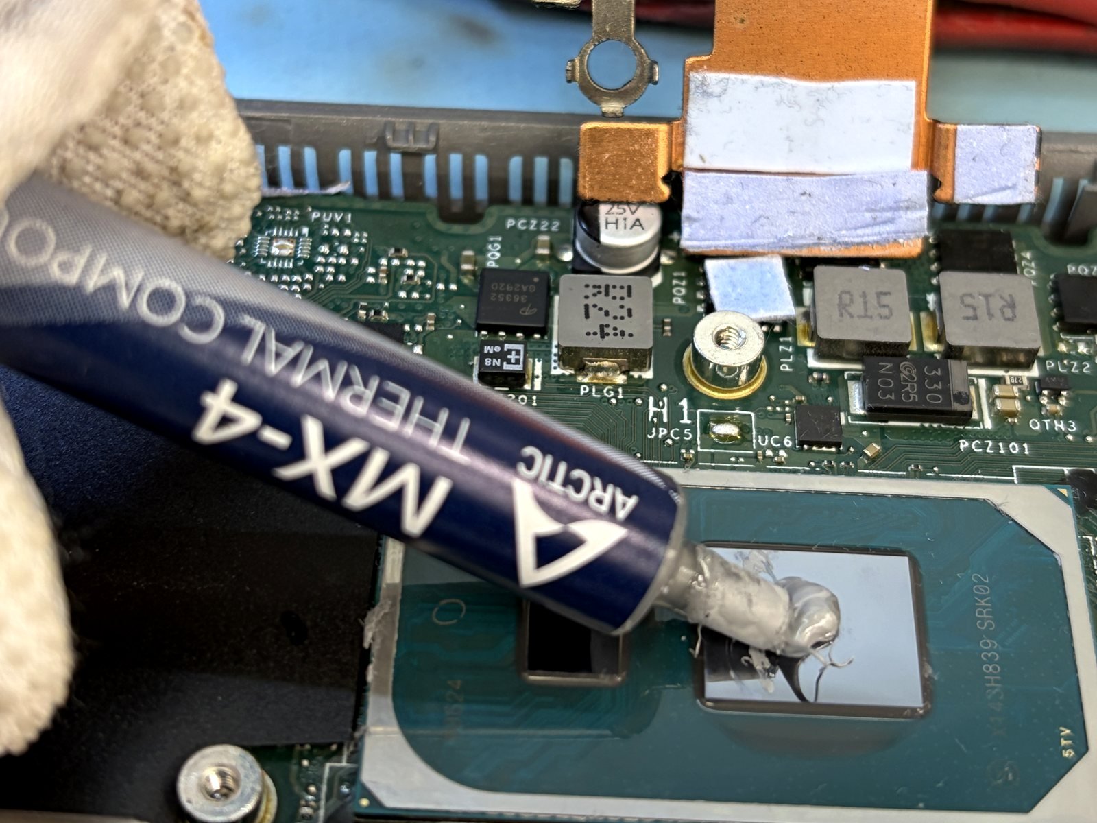Nieuwe Arctic MX-4 koelpasta wordt aangebracht op de gereinigde processor van een laptop