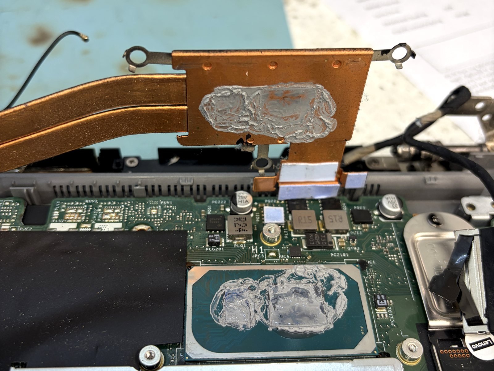 Uitgedroogde en gebarsten koelpasta op de processor en op het koperen koelblok van een laptop