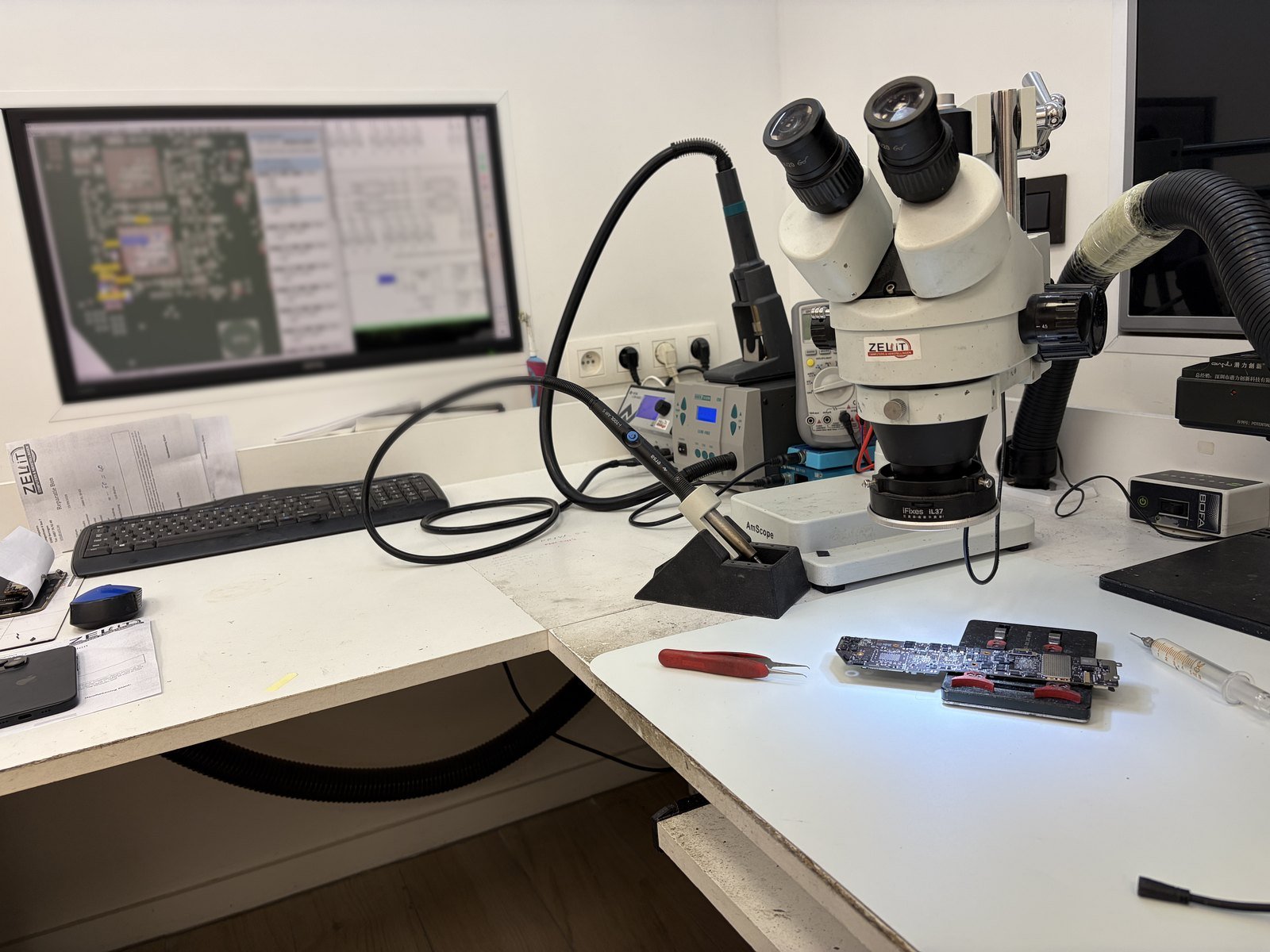 De werkplaats van ZeliT in Beringen met stereomicroscoop, soldeerstation en boardview op het scherm